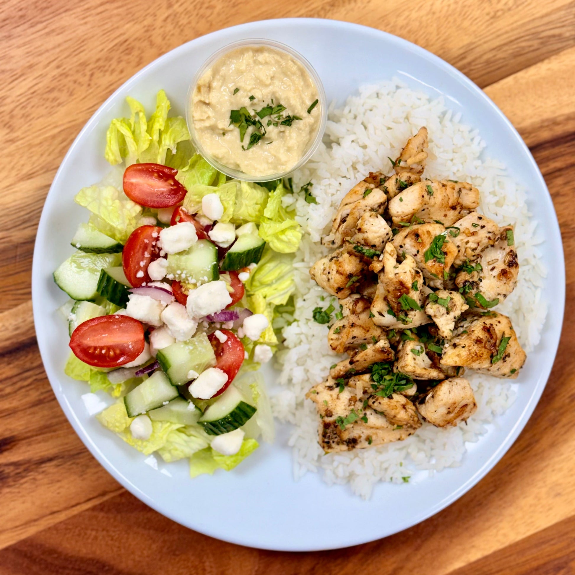 Mediterranean Marinated chicken, Jasmine rice, Greek salad, and a side of hummus.